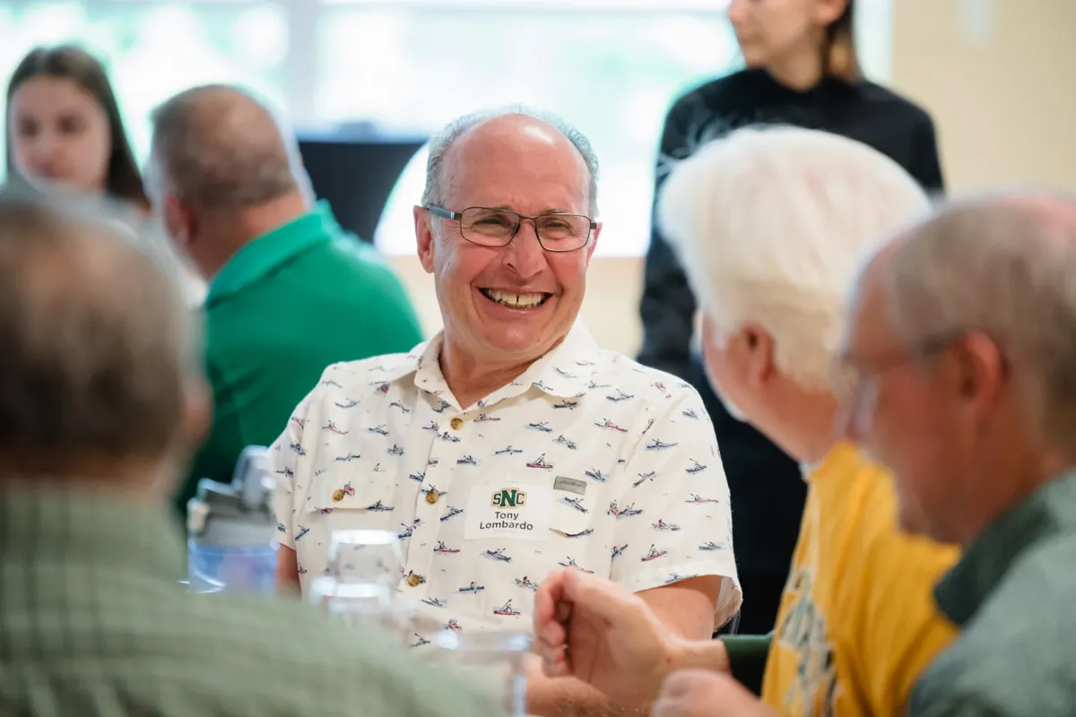 Alumni laughing together during a reunion event 