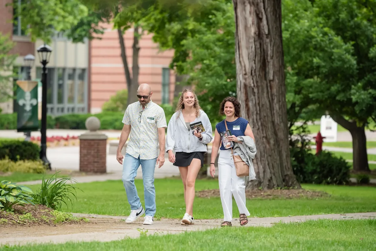 Three people walking across the St. Norbert College campus