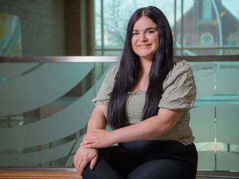 Female student sitting in front of a balcony