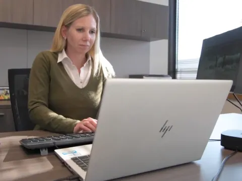 Wendy Van Lannen MBA ’20 works on her computer at her desk at work