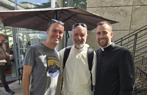 Father Mike Brennan in Rome with two SNC alumni.